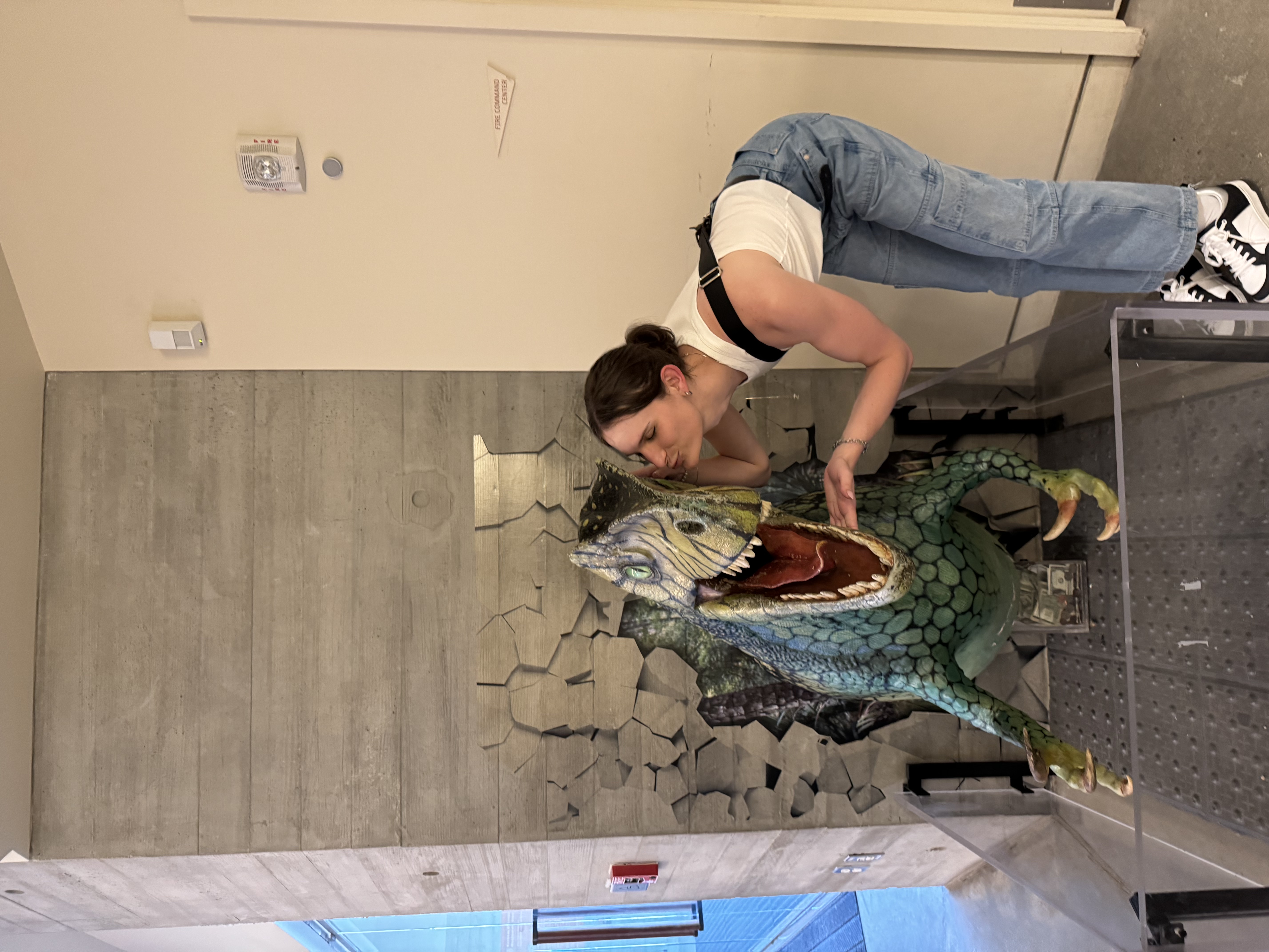 Zoe at the Dinosaur Museum, giving a kiss on the cheek to a dinosaur model